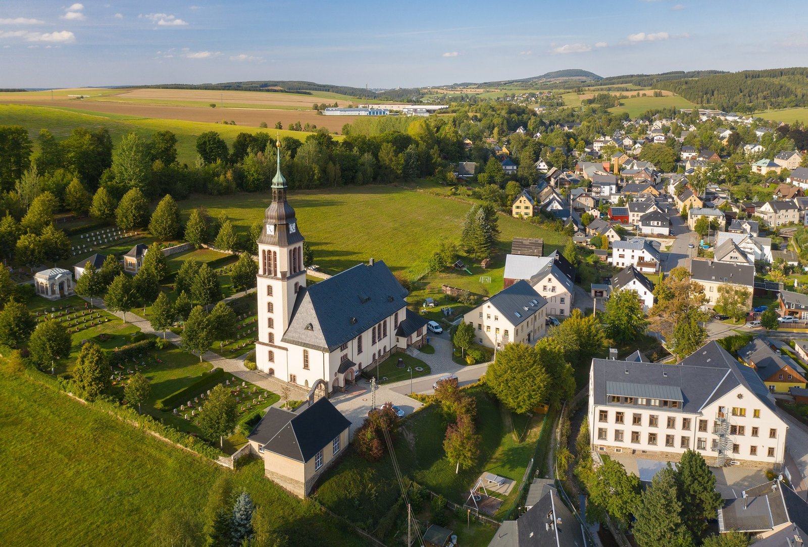 Luftbild der Himmelfahrtskirche mit dem Friedhof links daneben